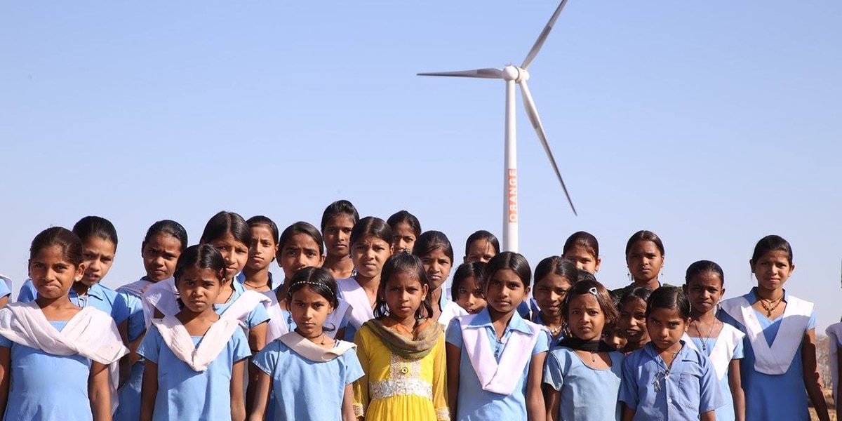 School children and wind turbine. Carbon offsetting project - India (Rajasthan): Bundled Wind Power.